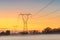 Power line in the late evening, hazy field, orange sky after sunset