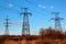 Power line pylons against blue sky background