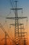 Power line pylons against sunset sky background