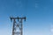 Power line tower stands on blue summer sky