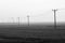 Power lines across a misty fen landscape
