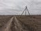 Power lines along a dirt road. Gloomy evening landscape