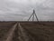 Power lines along a dirt road. Gloomy evening landscape