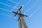 Power lines dripping with icicles against blue sky