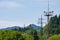 Power lines in the mountains covered with trees, towers with electricity