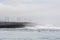 Power lines and pylons on the black shore of northern sea, Iceland