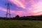 Power lines and pylons leading off into the distance with an incrediable sunset overhead