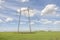 Power lines pylons next to a field