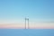 Power lines in snow field at pastel sunset