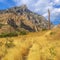 Power lines on yellow grass overlooking mountain