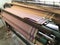 Power loom equipment weaving sarees by using wefts and plaiting using thousands of warps and this weaving industry running in