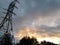 Power pylon against the evening sky, abstract background, wallpaper, disturbing mood, gloomy skies with clouds at sunset