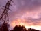 Power pylon against the pink  evening sky, abstract background, wallpaper, disturbing mood, gloomy skies with clouds at sunset