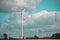 Power station with renewable energy windmills and a background of blue sky with large clouds