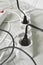 Power strip with different electrical plugs on white floor, closeup