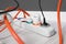 Power strip with different electrical plugs on white laminated floor indoors, closeup