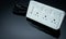 Power strip with three electrical standard socket on black background. White universal plug with overload protection. Fire