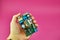 Power supply Board on pink background, top view. A person holds a printed circuit Board PCB with capacitors and diodes.