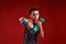 Power. A teenage boy engaged in sport, looking at camera while holding dumbbells. Isolated on red background. Training