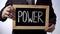 Power written on blackboard, businessman holding sign, business, politics