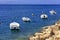 Powerboats and boats are anchored along the rocky coast of the Ionian Sea