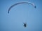 Powered paraglide or paramotor against blue sky. Paragliding