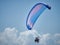 Powered paraglide or paramotor against blue sky. Paragliding