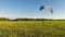 Powered paraglider pilot taking off with a back-mounted lightweight motor vehicle a paramotor on a beautiful summer day