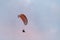 Powered paragliding, man flying high in a sky with parachute and engine on his back