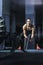 Powerful attractive muscular CrossFit trainer do battle workout with ropes