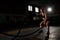 Powerful attractive muscular woman battle rope workout at the gym