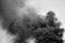 Powerful clouds of black smoke against the sky. Black and white. Background. The problem of waste disposal