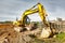 A powerful crawler excavator is working on a construction site. Close-up. Preparation of a pit for construction. Excavation