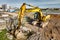 A powerful crawler excavator is working on a construction site. Close-up. Preparation of a pit for construction. Excavation