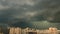 Powerful cumulonimbus thunderstorm clouds and squall over the city with multistory houses. Time lapse cloudscape heavy rain storm