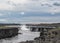 Powerful Dettifoss waterfall with black basalt columns and water spray in sunny day, North Iceland, Europe