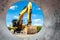 Powerful excavator at the construction site. View of the excavator through the pipe. Close-up of earthmoving machinery.