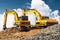 Powerful excavators at a construction site against a blue cloudy sky. Earthmoving construction equipment. Lots of excavators