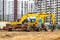 Powerful excavators at a construction site against a blue cloudy sky. Earthmoving construction equipment. Lots of excavators