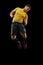Powerful, flying above the field. Young football, soccer player in action, motion isolated on black background .