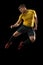 Powerful, flying above the field. Young football, soccer player in action, motion isolated on black background .