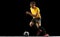 Powerful, flying above the field. Young football, soccer player in action, motion isolated on black studio background .