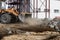 A powerful front loader on a construction site clears up the battle after dismantling reinforced concrete structures. Moving soil