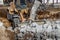 A powerful front loader on a construction site clears up the battle after dismantling reinforced concrete structures. Moving soil