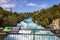 Powerful Huka Falls with a sign with information about the falls, on the Waikato River near Taupo North Island New Zealand