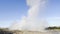 Powerful Icelandic Strokkur Geyser erupting from a hole releasing steam