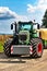 Powerful modern green tractor on field. Blue sky with clouds. Modern agricultural machinery. Work on the farm