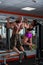 Powerful, muscular, strong, guy and girl, train back. together are tightened on a horizontal bar. Sports hall