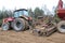 A powerful red diesel tractor with a connected sowing unit, a combine with large wheels plows the land, sows crops, performs agrar