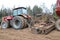 A powerful red tractor with a connected seeding unit, a combine, a drill with large wheels plows the land, sows crops, performs ag